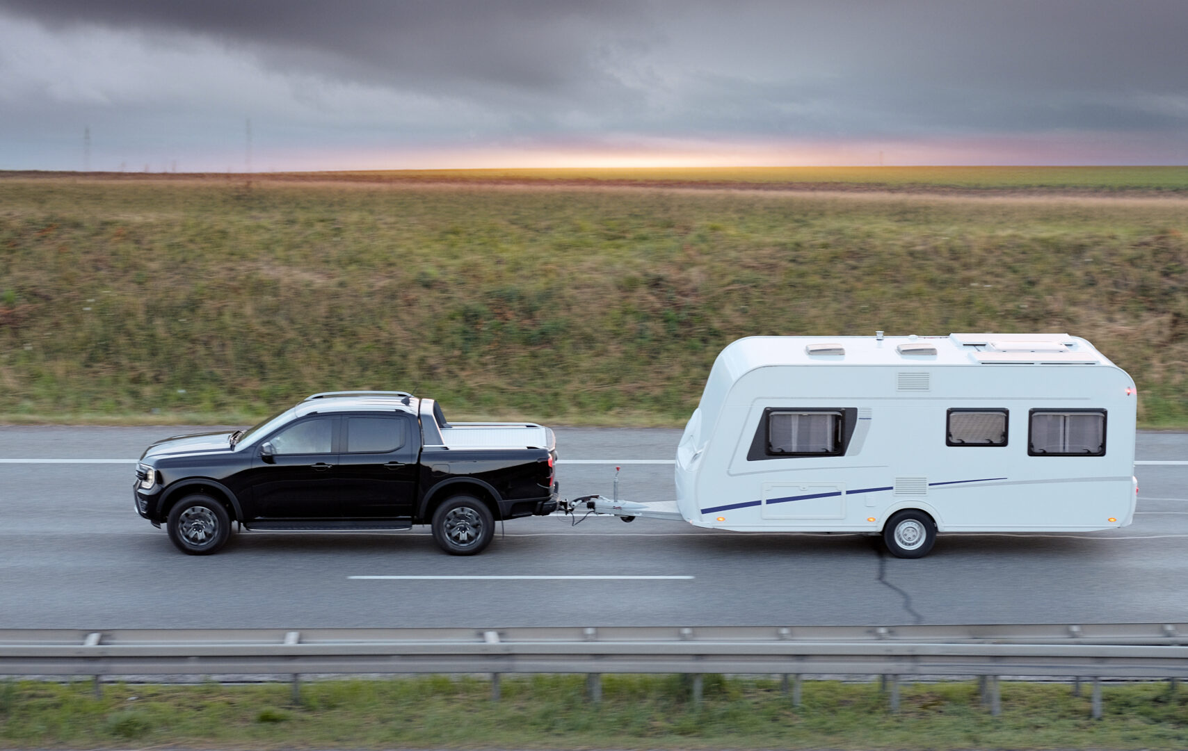 family-vacation-trip-on-black-pickup-truck-with-white-camper-trailer